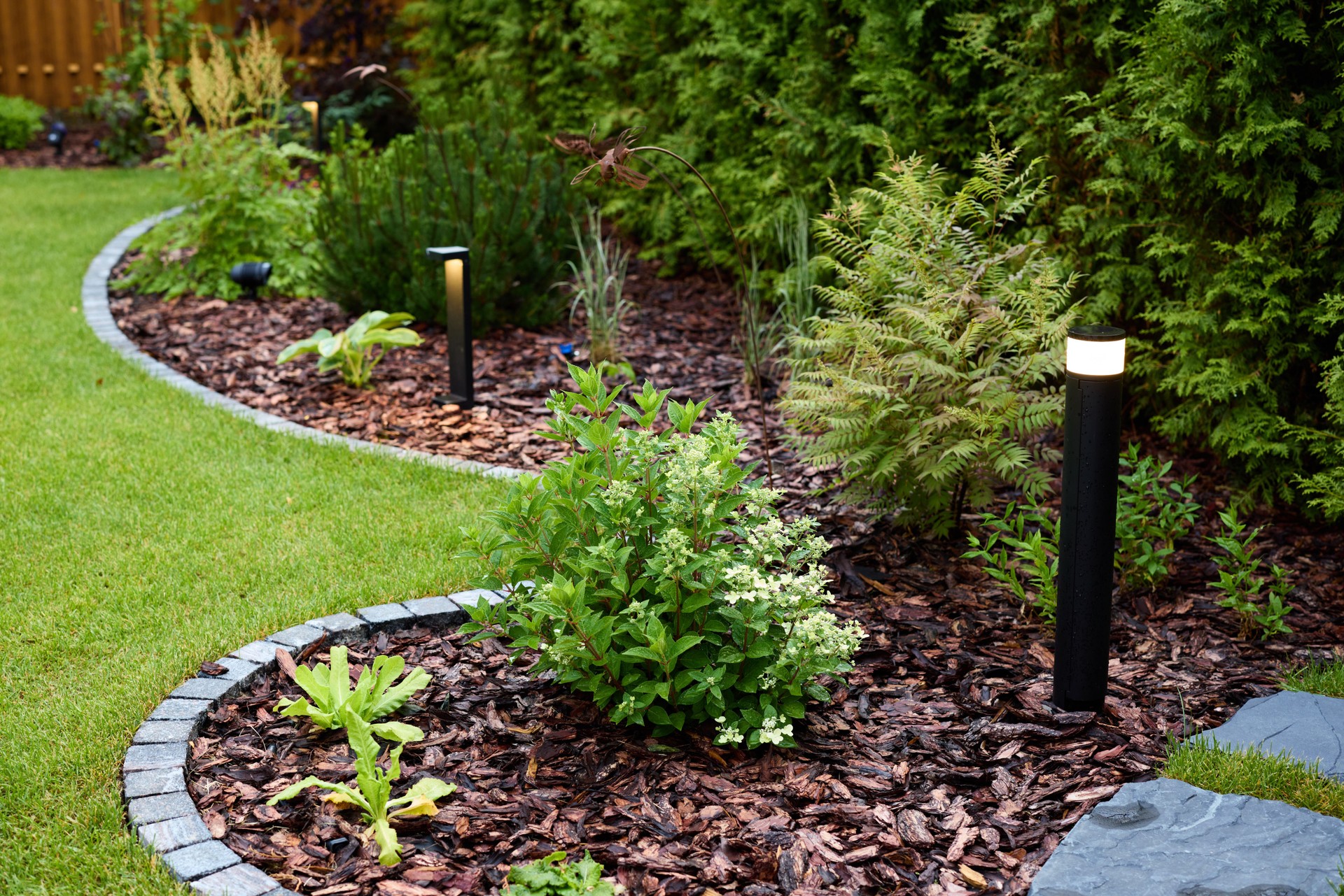 A Beautifully Landscaped Garden Featuring Striking LED Lights and Fresh Mulch Enhancements